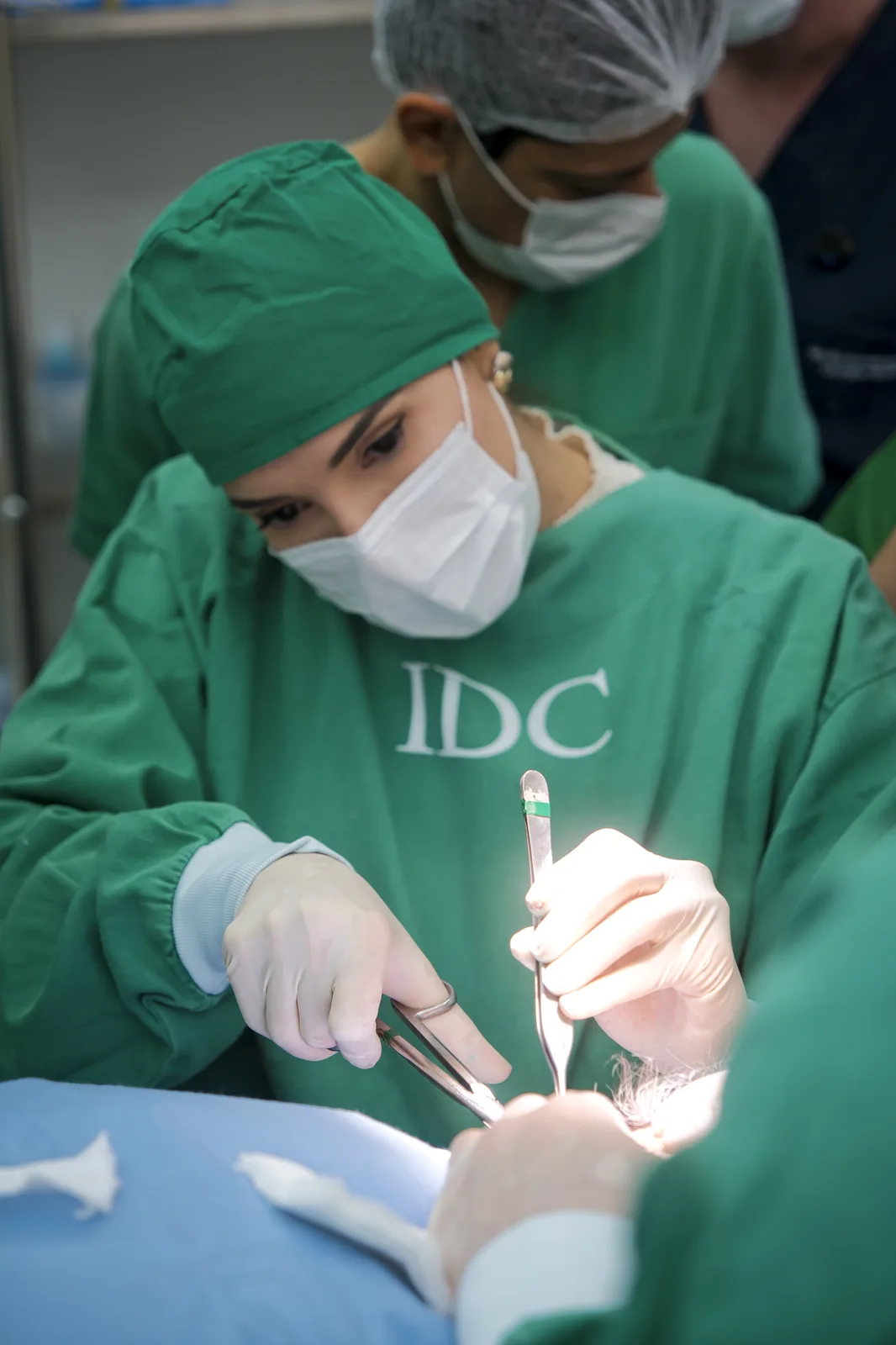 Aluno operando sob supervisão direta em sala cirúrgica do IDC